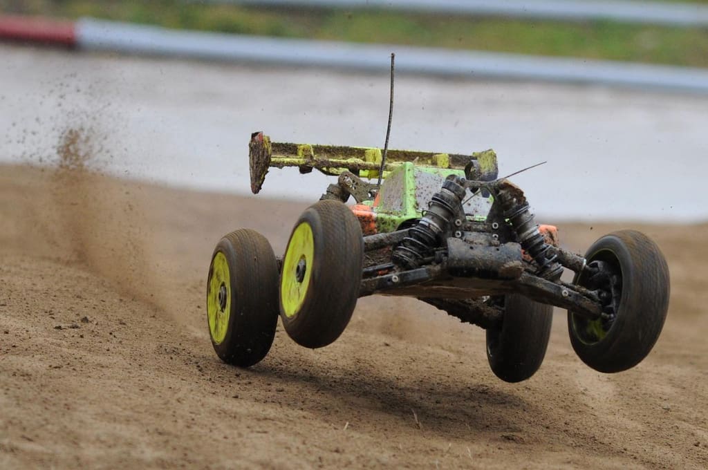 RC buggy landing a jump on a race track