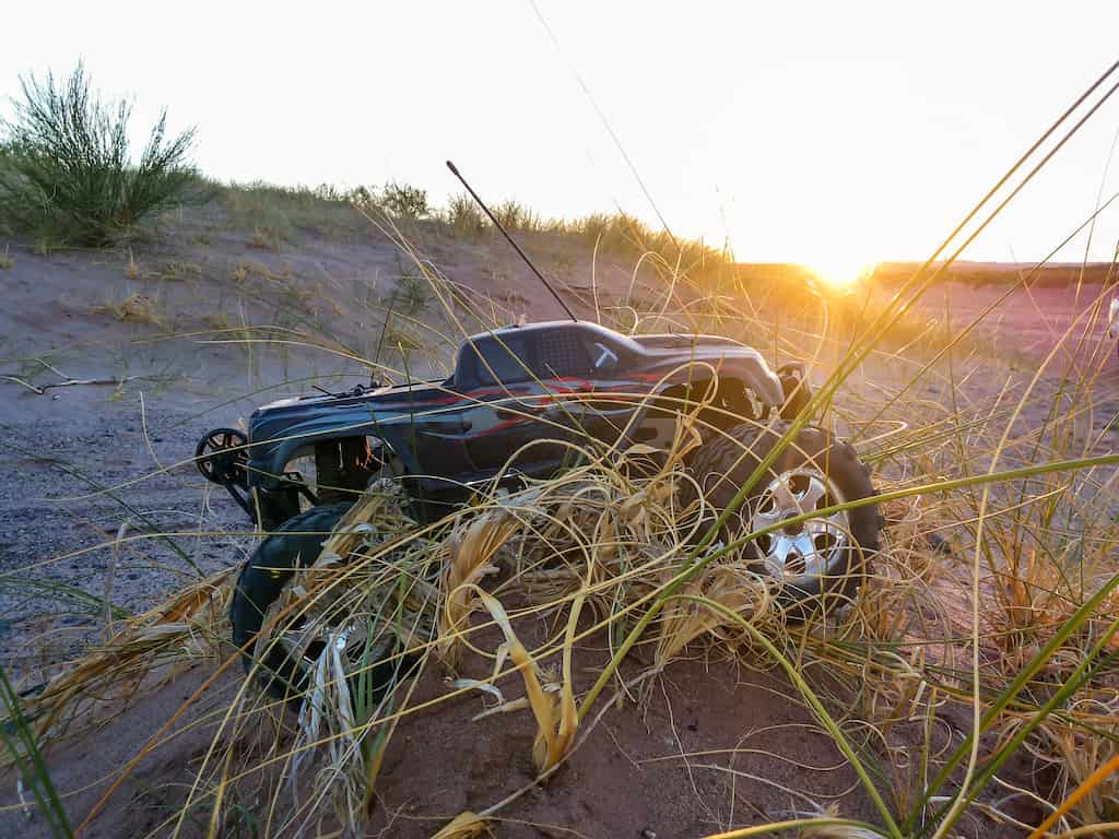 rc truck in the sand and heavy grass