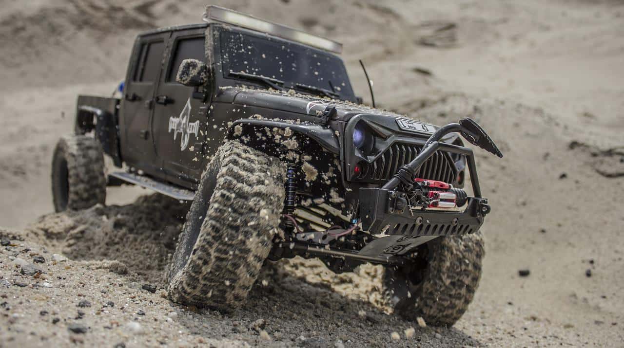 closeup view of an rc jeep driving in the sand